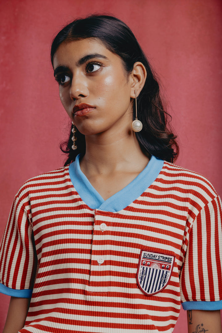 Girl wearing a red and white striped candy cane shirt with a blue collar 