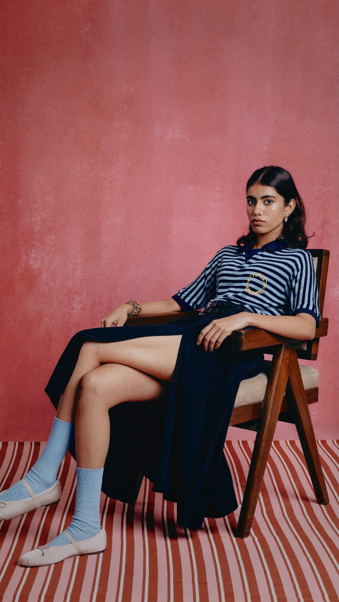 Girl wearing a the Nerazzurri blue and black striped shirt with a gold heart design against a pink background